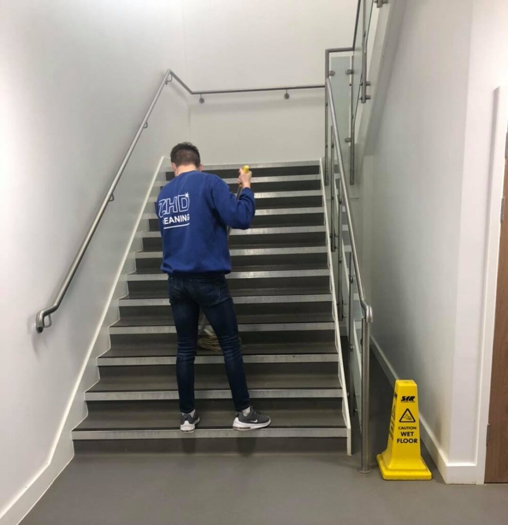 man mopping laminate stair well