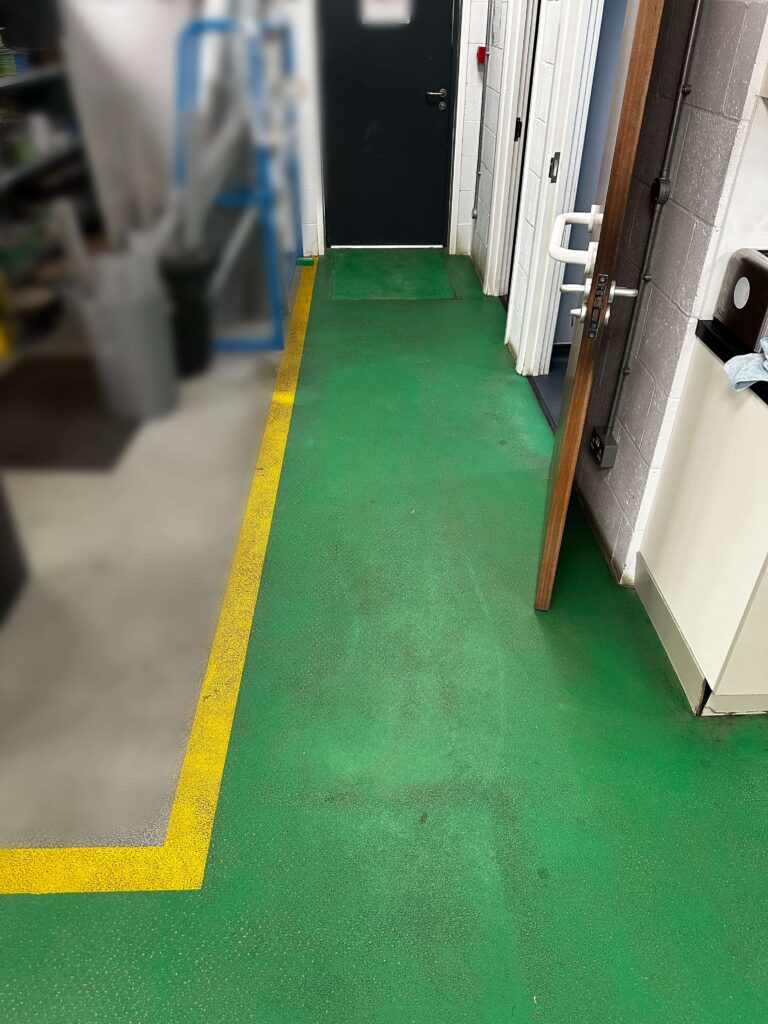 green hard floor with black dirt all over it